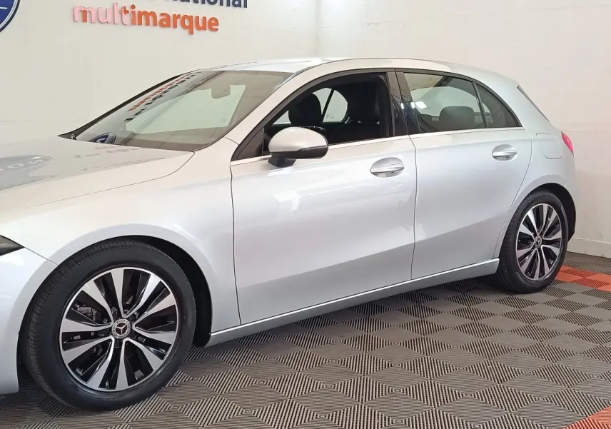 Vue latérale droite d'une Mercedes Classe A 180 d Business Line gris clair avec jantes alliage bicolores.