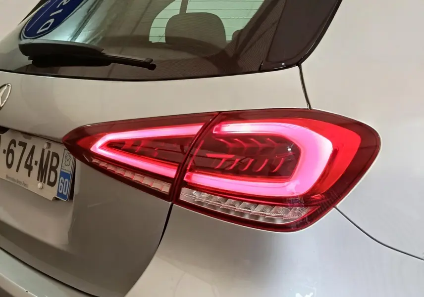 Gros plan sur le feu arrière droit allumé d'une Mercedes Classe A 180 d Business Line gris clair.