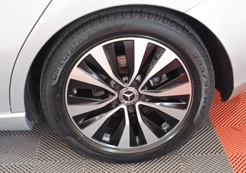 Gros plan sur la roue avant droite d’une Mercedes Classe A 180 d Business Line gris clair avec jante alliage bicolore.