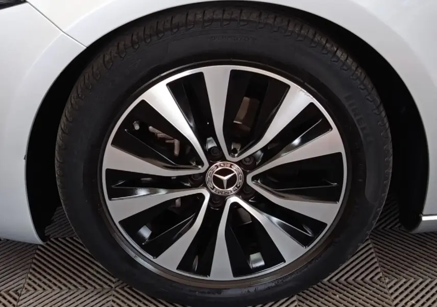 Gros plan sur la roue avant droite d’une Mercedes Classe A 180 d Business Line gris clair avec jante alliage bicolore.
