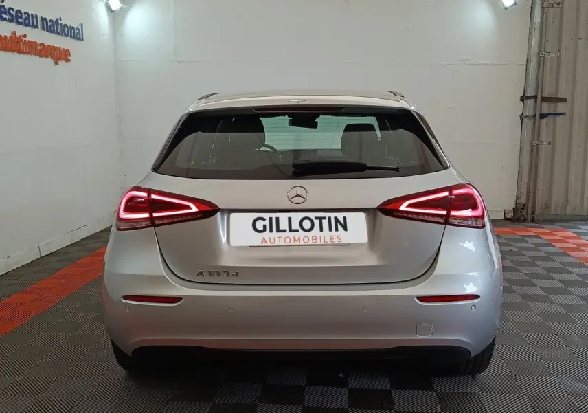 Vue arrière d'une Mercedes Classe A 180 d Business Line gris clair avec feux LED allumés dans un garage.