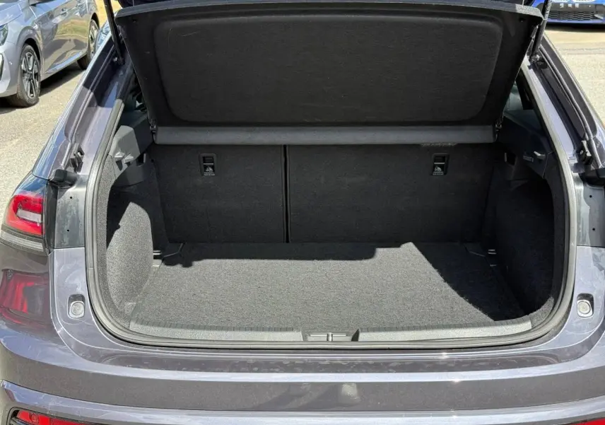 Coffre ouvert vu de l'arrière d'un Volkswagen Taigo gris Ascot 2025, montrant l'espace de chargement vide.