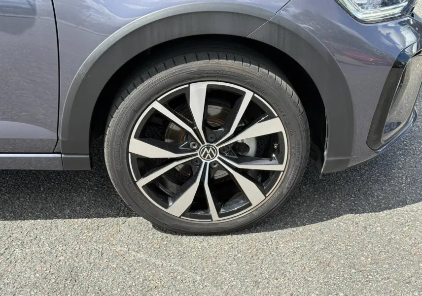 Gros plan sur la roue avant droite avec jante alliage bicolore du Volkswagen Taigo gris Ascot 2025 R-Line.