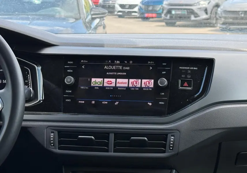 Vue intérieure du tableau de bord du Volkswagen Taigo gris 2025, avec écran tactile central affichant les radios DAB.