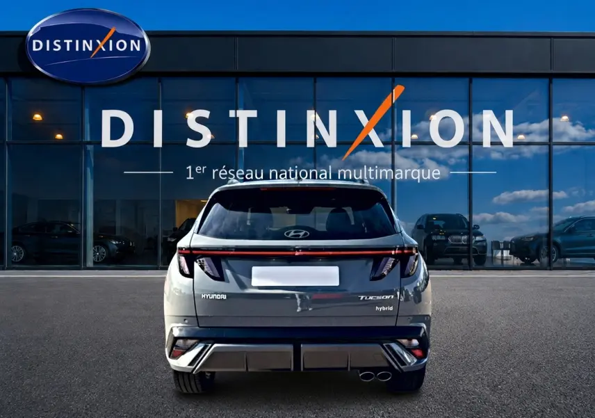 Vue arrière d’un Hyundai Tucson gris shadow hybride, avec feux LED et double sortie d’échappement visible.