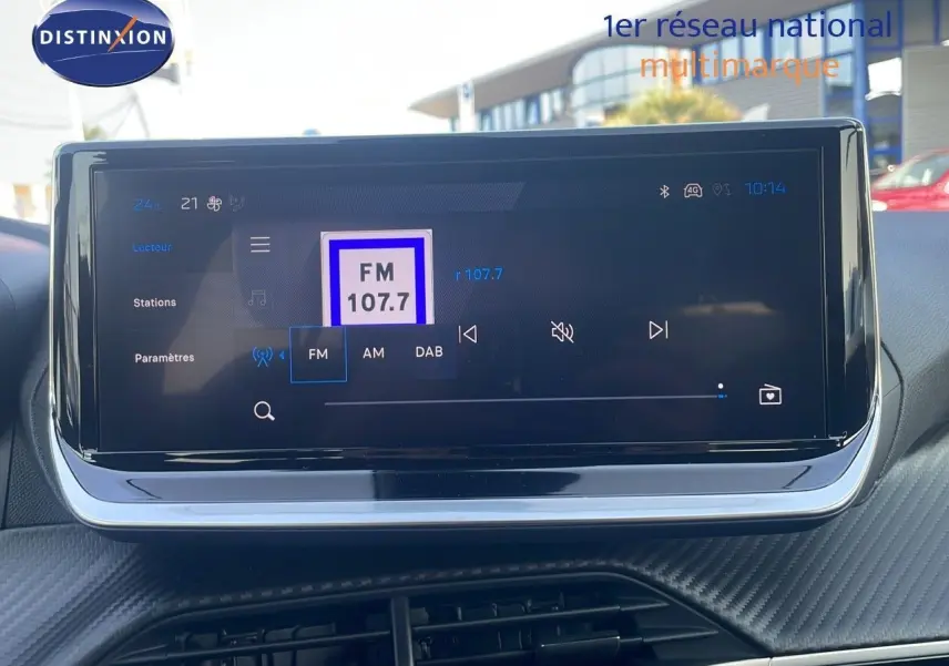 Écran tactile central du tableau de bord du Peugeot 2008 Hybrid 136ch Allure, affichant la radio FM sur 107.7 MHz.