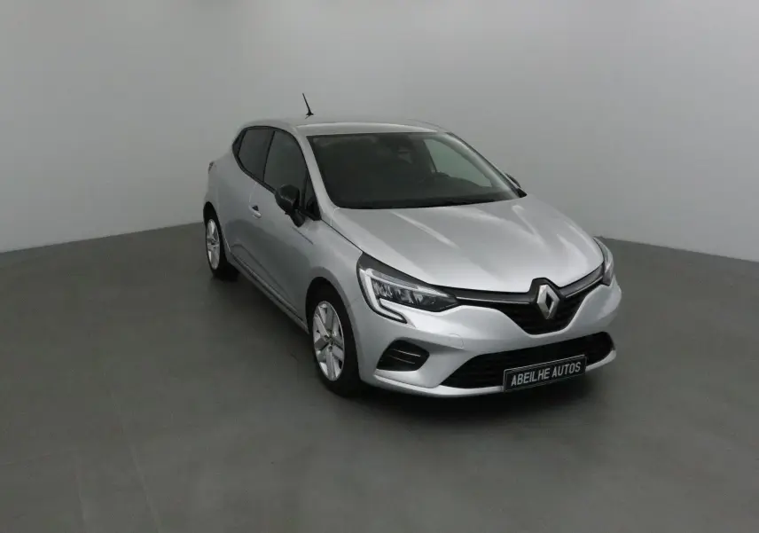 Renault Clio V gris platine vue 3/4 avant droit dans un studio, avec calandre et phares LED distinctifs.