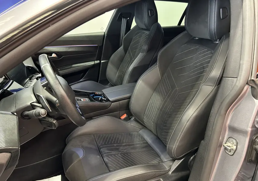 Intérieur de la Peugeot 508 SW 2024 en gris artense, vue côté conducteur sur les sièges en cuir et alcantara avec surpiqûres blanches.