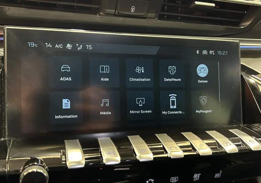 Écran tactile central de la Peugeot 508 SW 2024 affichant les menus ADAS, climatisation et multimédia avec commandes piano en dessous.