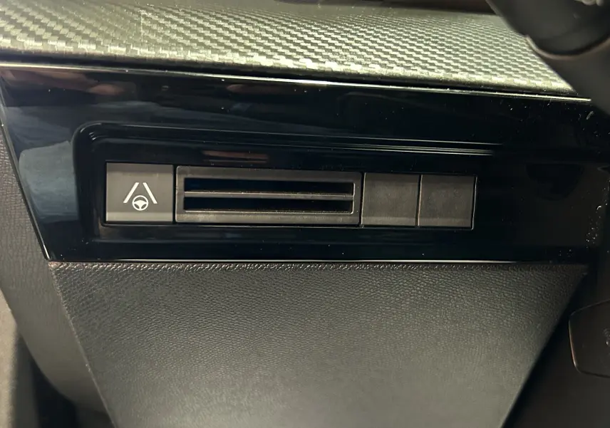 Détail du tableau de bord noir de la Peugeot 508 SW 2024 avec bouton d'assistance au maintien de voie visible.