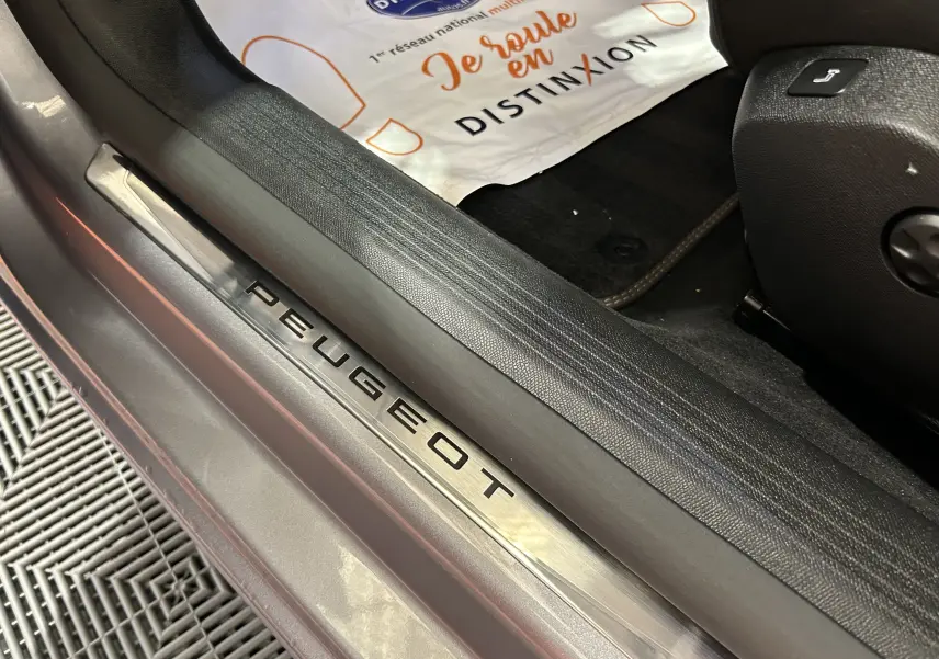 Gros plan sur la plaque de seuil de porte Peugeot dans l'habitacle d'une 508 SW gris artense.