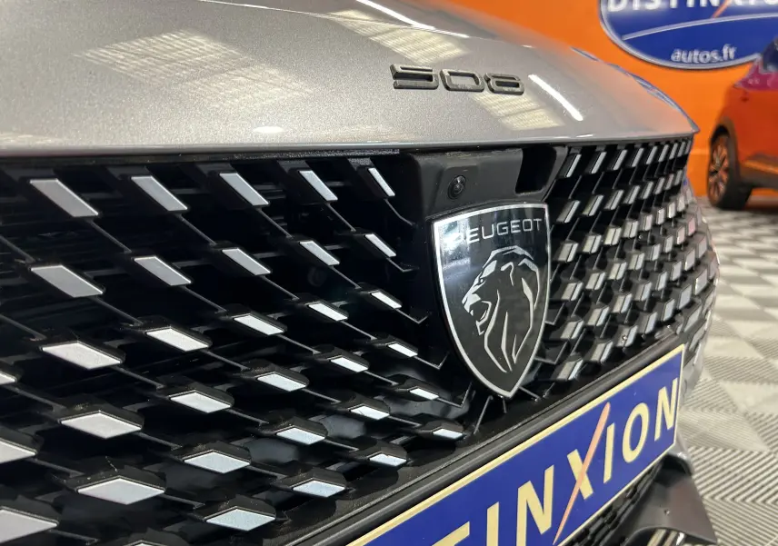 Gros plan sur la calandre avant gris artense du Peugeot 508 SW avec logo lion et caméra 360° intégrée.
