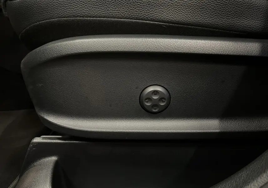 Détail du bouton de réglage électrique sur le côté gauche d’un siège en cuir noir du Mercedes GLA 250E AMG Line 2023.
