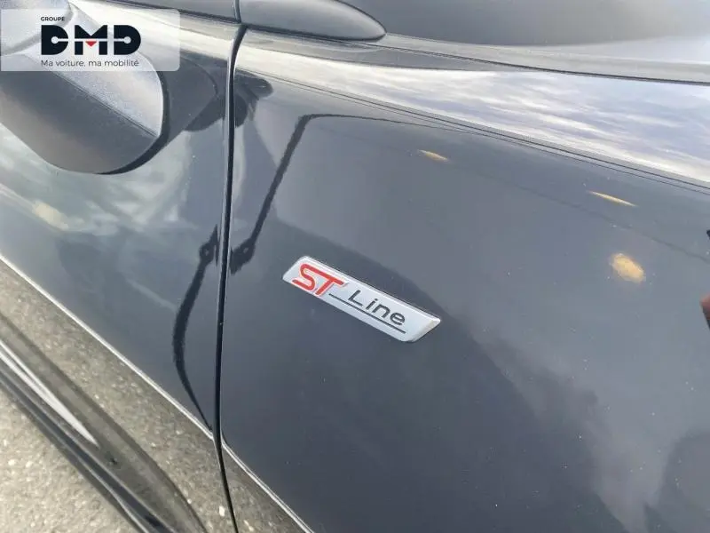 Gros plan sur l'écusson ST-Line sur la porte côté gauche d'une Ford Puma noir agate métallisée.