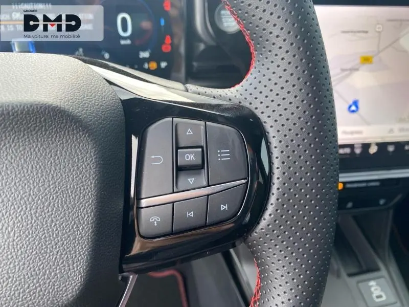 Gros plan sur les commandes multifonctions du volant perforé noir avec surpiqûres rouges du Ford Puma 2026.