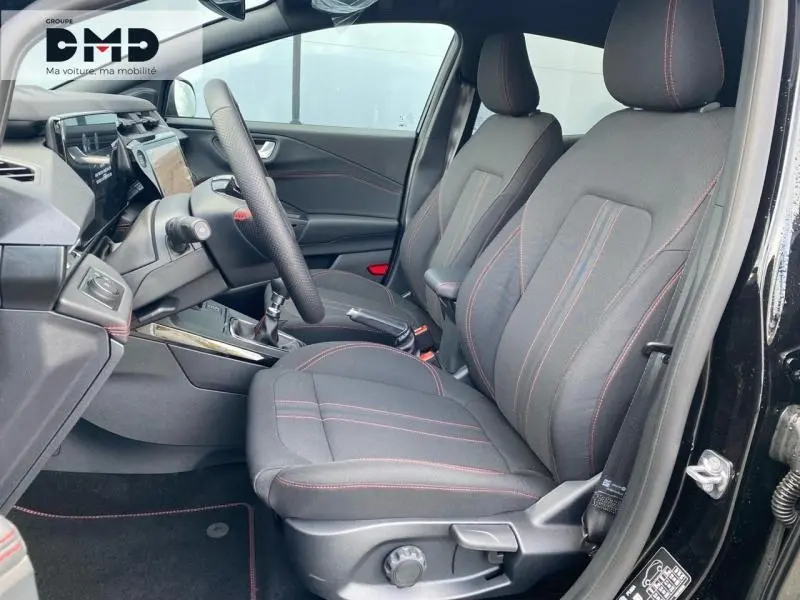 Vue intérieure côté conducteur du Ford Puma noir Agate Métallisée, sièges tissu noir avec surpiqûres rouges et volant multifonction.
