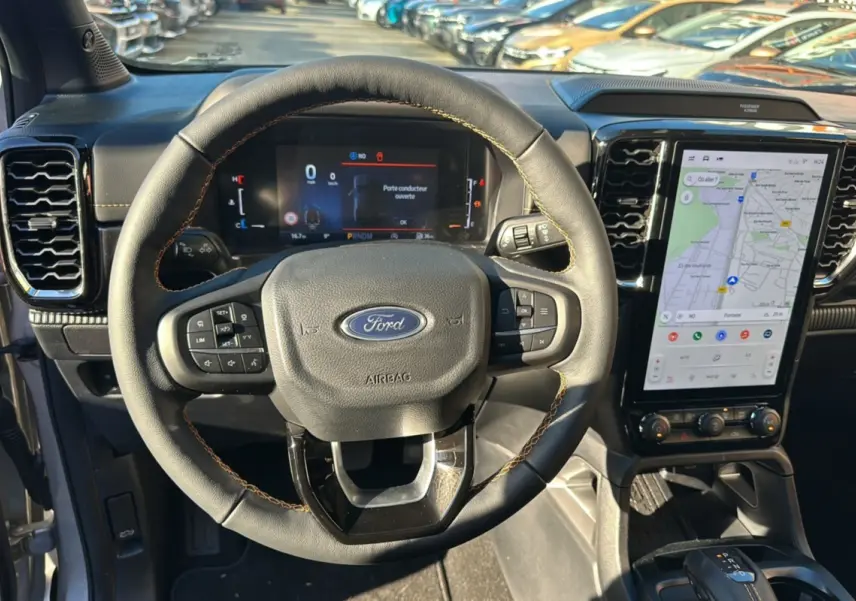 Vue intérieure centrée sur le volant cuir Ford avec commandes multifonctions et écran tactile vertical du Ford Ranger 2026.