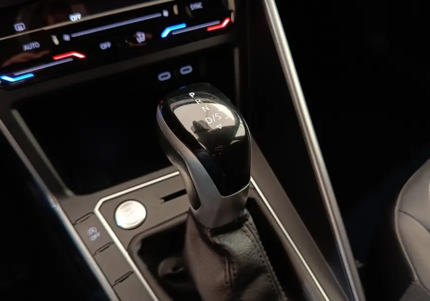 Le levier de vitesses automatique noir et argenté du Volkswagen Taigo 1.5 TSI 150 DSG Style, avec commandes et éclairage ambiant.