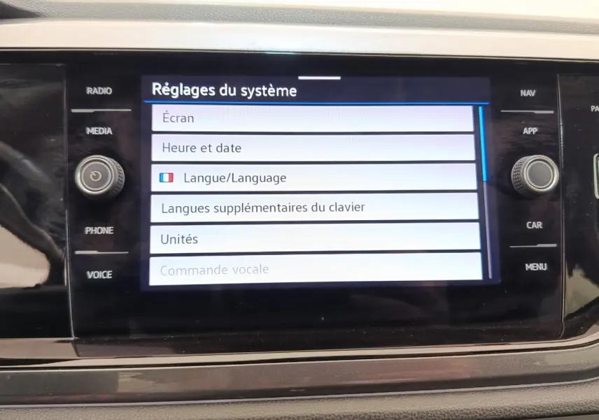 Écran tactile central du Volkswagen Taigo gris foncé, affichant les réglages du système en mode langue.