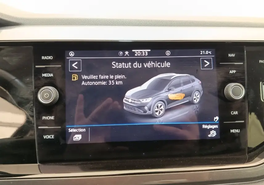 Écran tactile central affichant le statut du véhicule Volkswagen Taigo gris foncé en vue 3/4 avant droite.