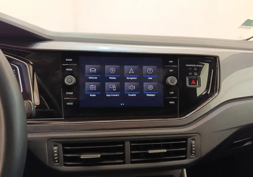 Vue rapprochée du tableau de bord noir du Volkswagen Taigo 1.5 TSI 150 DSG Style avec écran tactile central allumé.