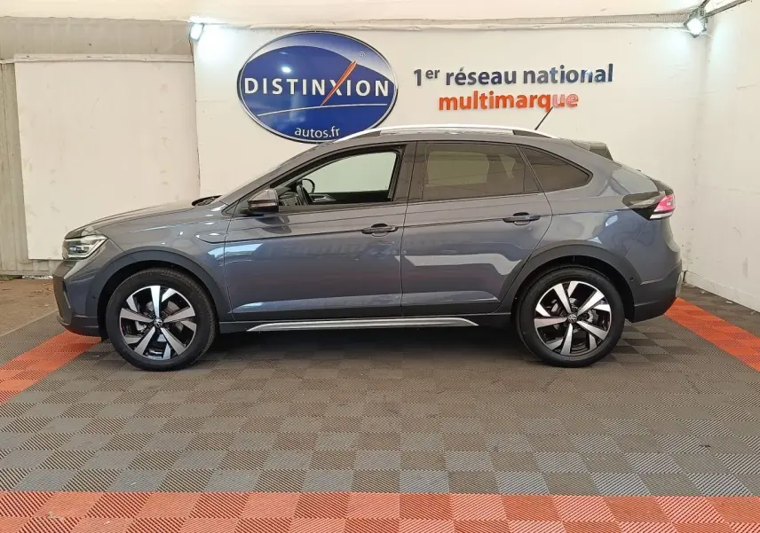 Vue latérale droite d’un Volkswagen Taigo gris foncé 2023, avec jantes alliage et toit panoramique visible.