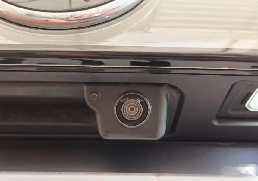 Gros plan sur la caméra de recul noire intégrée au hayon arrière du Volkswagen Taigo gris foncé 2023.