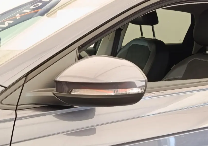 Rétroviseur droit gris foncé du Volkswagen Taigo 1.5 TSI 150 DSG Style 2023 avec siège avant visible.