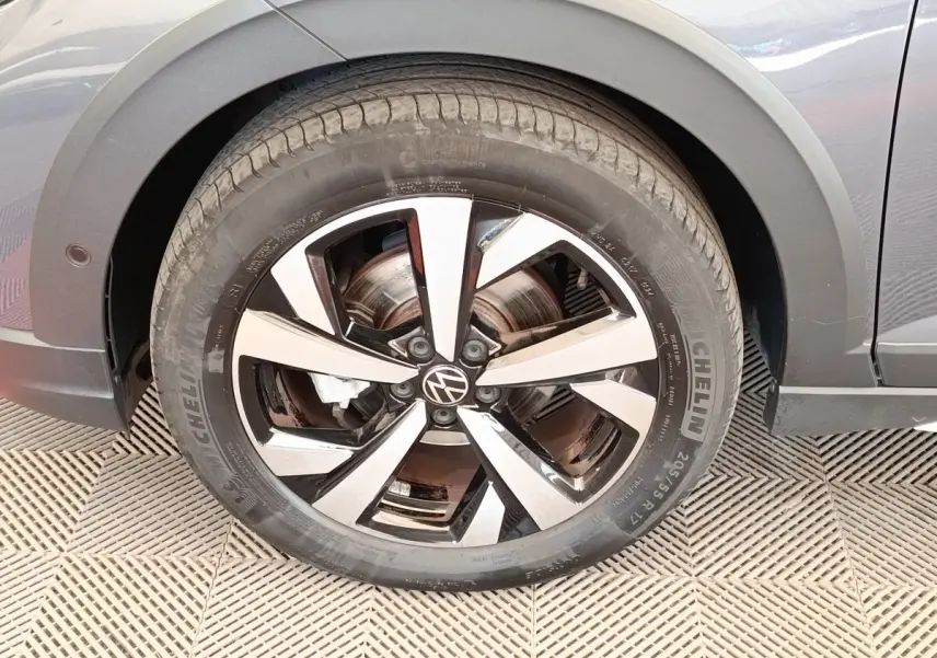 Gros plan sur la roue avant gauche gris foncé du Volkswagen Taigo 2023 avec jante alliage bicolore et logo VW.
