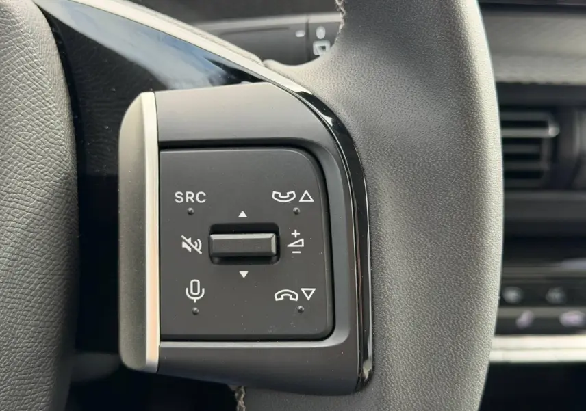 Gros plan sur les commandes multifonctions noires à gauche du volant du Citroën C3 2025, version 1.2 Turbo 100ch MAX.