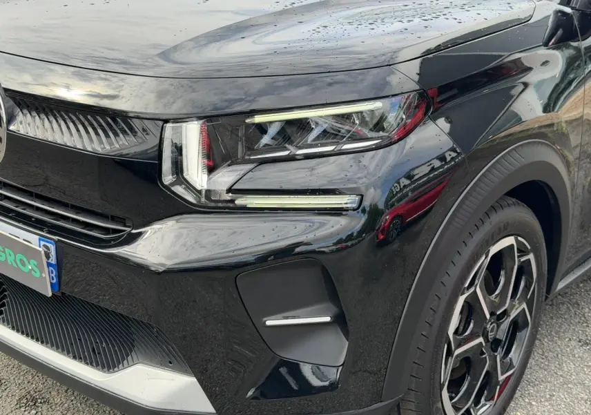 Gros plan sur l'avant droit de la Citroën C3 2025 noire, mettant en valeur ses phares LED et sa jante au design moderne.