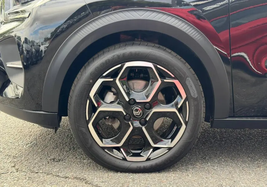 Gros plan sur la roue avant gauche noire d’une Citroën C3 1.2 Turbo 2025 avec jante hexagonale bicolore.