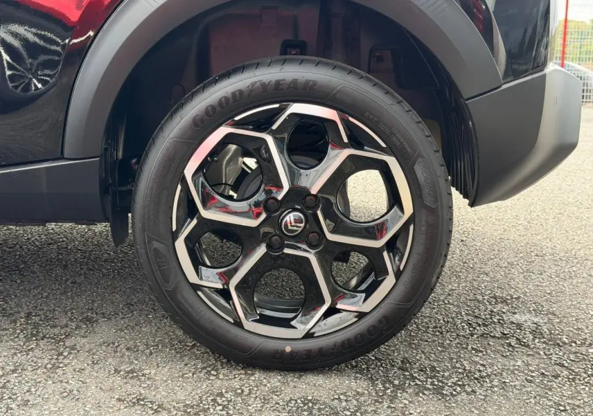 Gros plan sur la roue arrière droite noire d'une Citroën C3 1.2 Turbo 100ch MAX 2025 avec jante alliage au design géométrique.