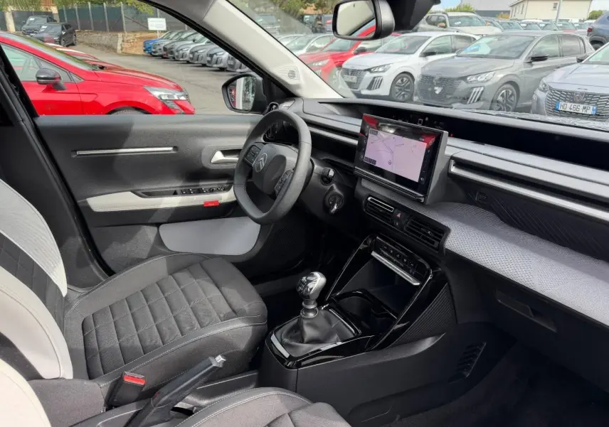 Intérieur de la Citroën C3 1.2 Turbo 2025 vu côté conducteur, avec tableau de bord noir et écran tactile central.