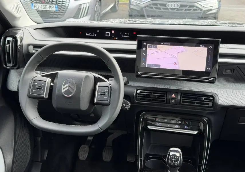 Vue intérieure centrée sur le volant et la console centrale d'une Citroën C3 noire avec boîte manuelle et écran tactile.