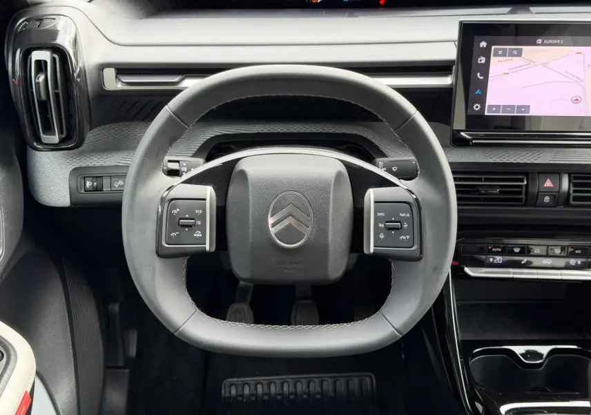 Vue frontale du volant noir de la Citroën C3 1.2 Turbo 2025 avec commandes intégrées et écran tactile de navigation.