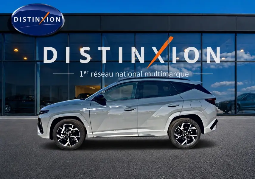 Hyundai Tucson 2026 gris shadow en profil droit, avec jantes alu noires et toit panoramique visible.