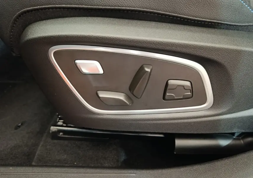 Gros plan sur les commandes électriques de réglage du siège avant en cuir noir du Renault Austral gris clair 2024.