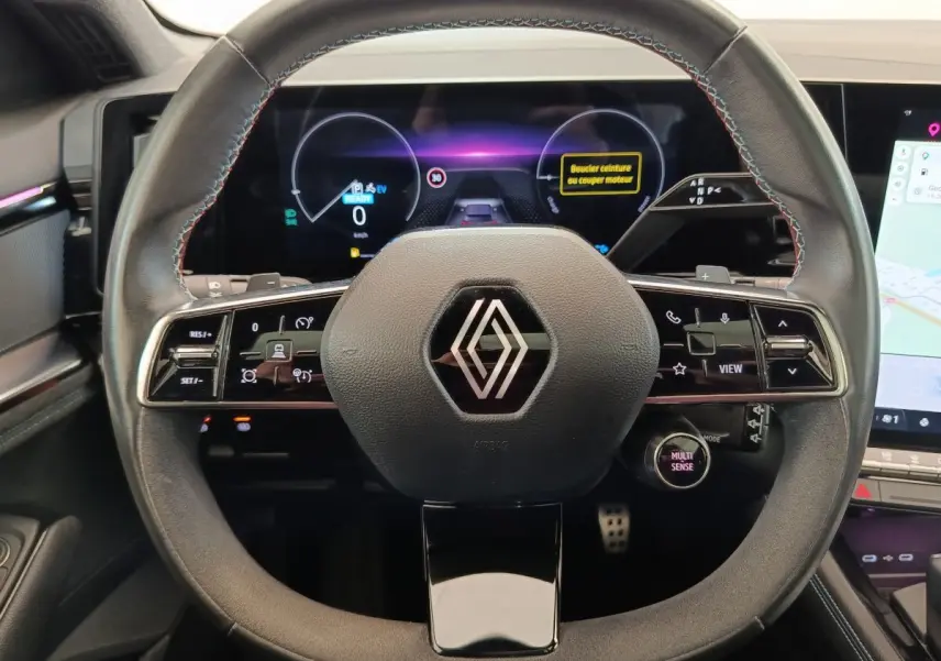Vue rapprochée du volant en cuir suédé noir du Renault Austral 2024 avec commandes multifonctions et tableau de bord digital.