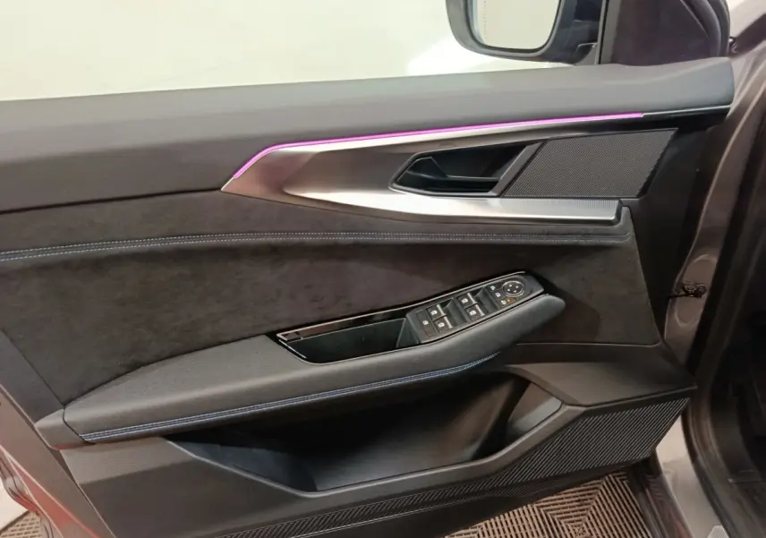 Vue intérieure du panneau de porte avant droit du Renault Austral gris clair avec éclairage d'ambiance violet et commandes de vitres.