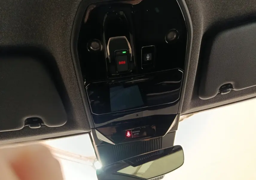 Vue intérieure en plongée du plafonnier noir brillant avec bouton SOS et indicateur airbag passager du Renault Austral gris clair.