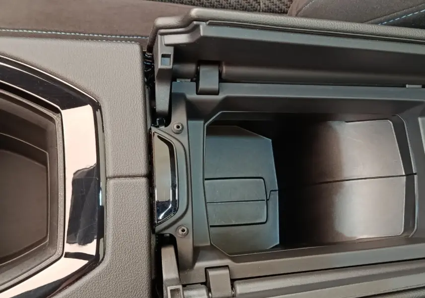 Vue rapprochée de la console centrale ouverte du Renault Austral Iconic Esprit Alpine gris clair, montrant le rangement intérieur.