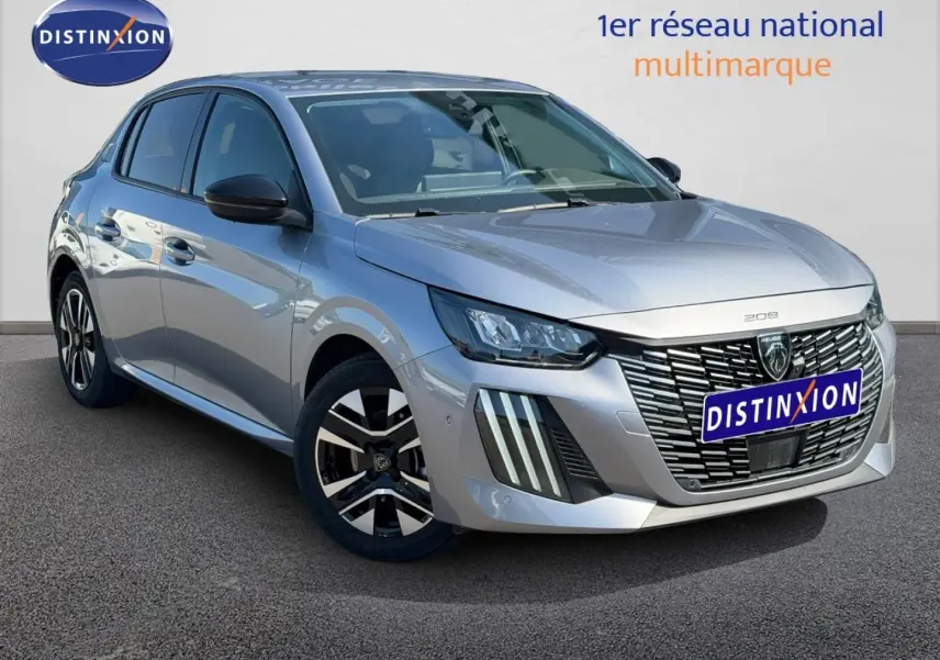 Peugeot 208 gris Artense vue 3/4 avant droit, avec calandre distinctive et jantes alliage noires et argentées.