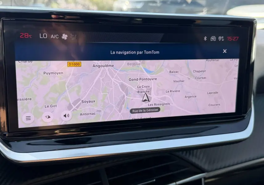 Écran tactile central de navigation TomTom dans l’habitacle d’une Peugeot 208 gris Artense, vue de face rapprochée.