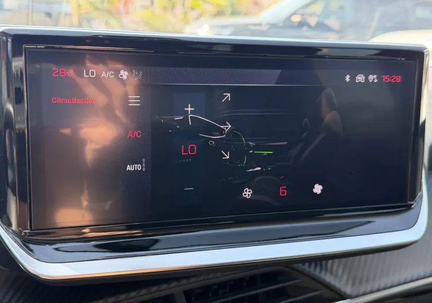 Écran tactile de la climatisation dans l'habitacle du Peugeot 208, affichant la température et les réglages.