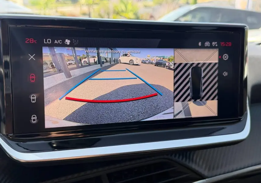 Écran tactile intérieur montrant la caméra de recul et vue 360° du Peugeot 208 gris Artense, tableau de bord moderne.