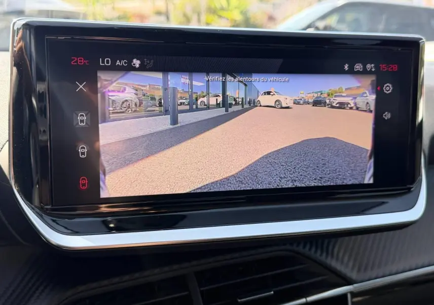 Écran tactile intérieur de la Peugeot 208 2025 affichant la caméra de recul avec vue arrière du parking.