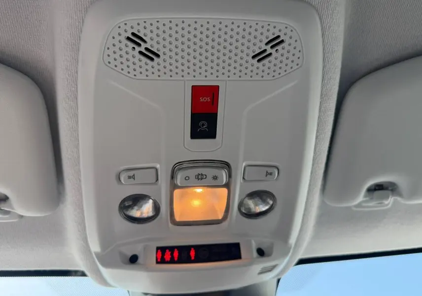 Plafonnier intérieur avec commandes d’éclairage et bouton SOS dans une Peugeot 208 gris Artense, vue de dessous.