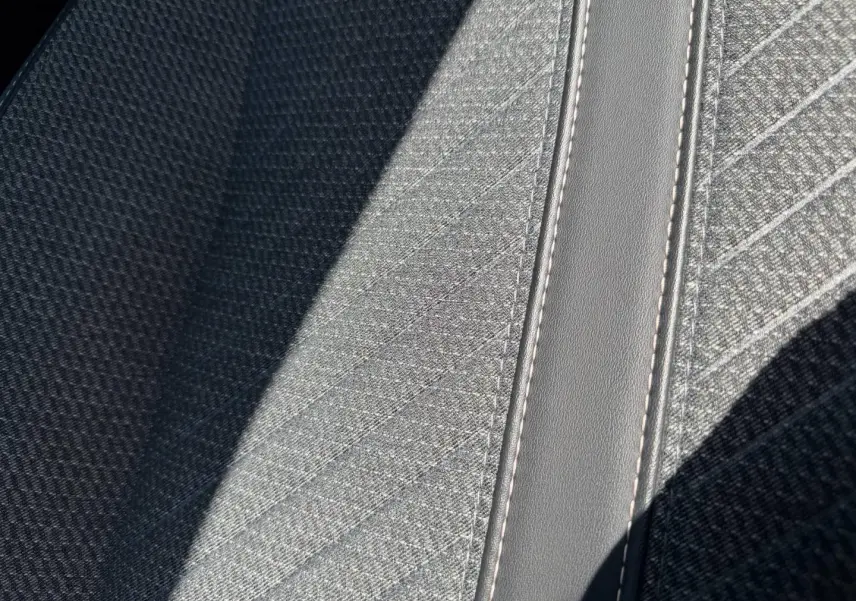 Détail du tissu gris clair Casual Lomsa avec surpiqûres sur la banquette avant du Peugeot 208 1.2 100ch Allure 2025.