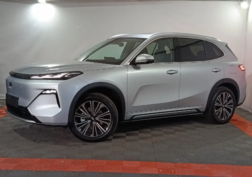 Vue de profil côté gauche d’un SUV Geely STARRAY gris clair avec jantes alliage et feux arrière allumés.